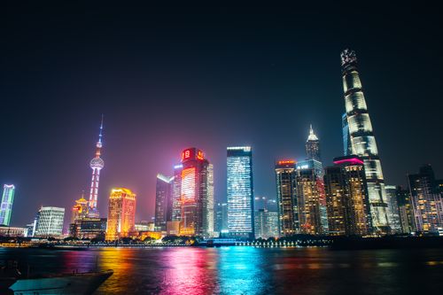 Free Stunning night view of Shanghai's illuminated skyline with colorful reflections on the river. Stock Photo