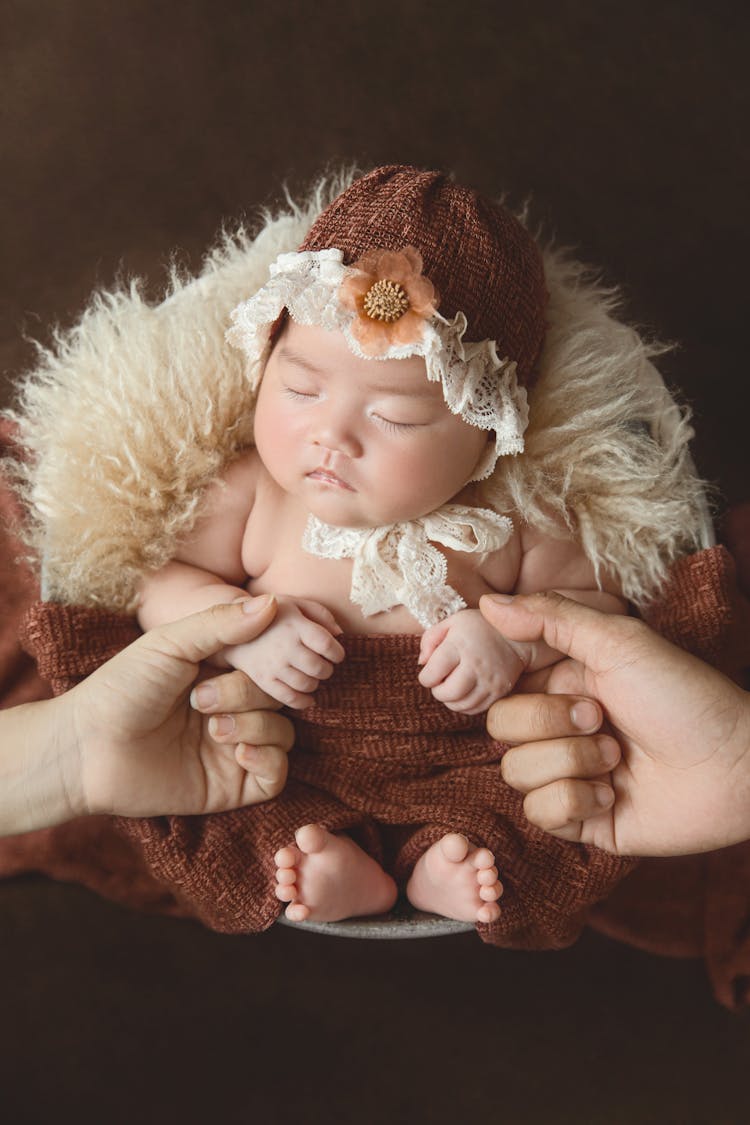 Parents Hands Holding Sleeping Baby