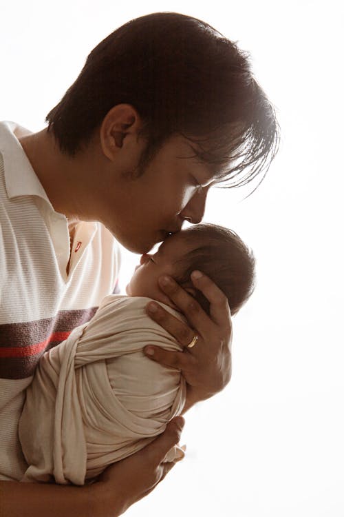 Father Holding and Kissing Baby