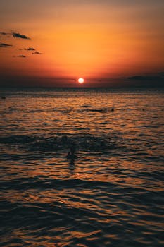 Dramatic ocean sunset with vivid orange and red hues creating a serene and captivating view.
