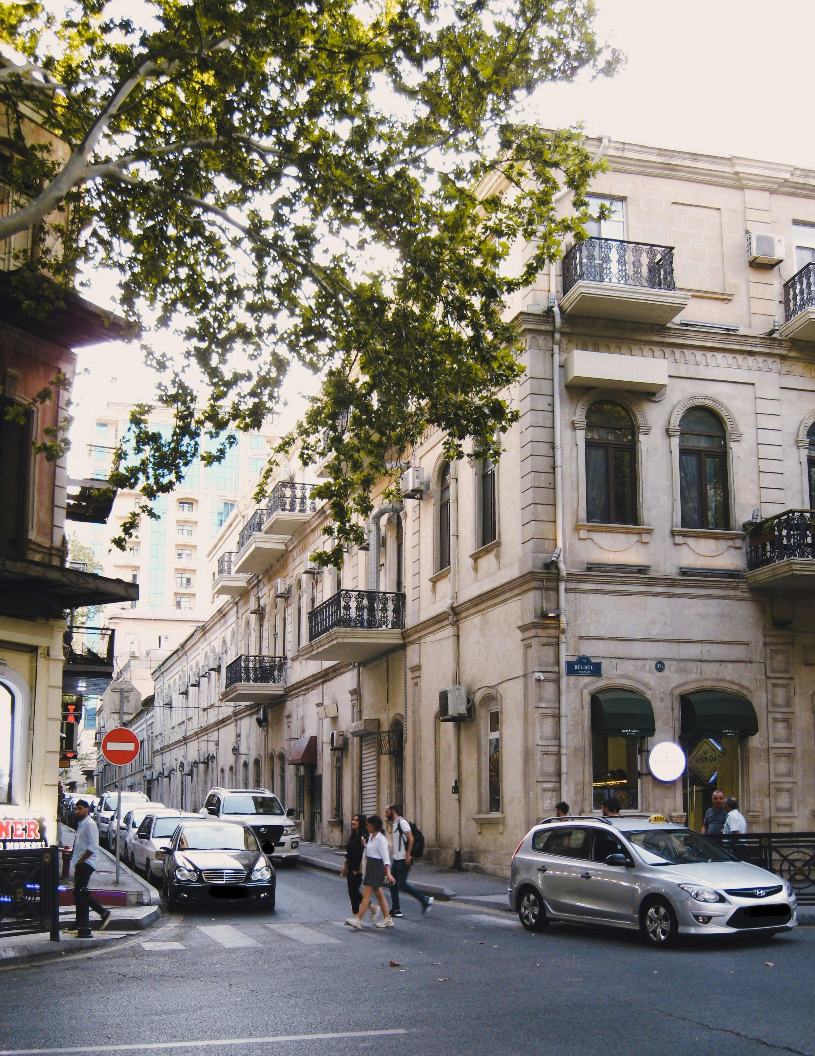 Free Charming urban street in Baku featuring classical architecture, pedestrians, and traffic. Stock Photo