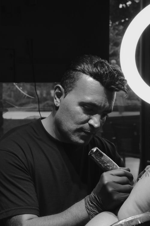 Free Tattoo artist in Aydın, Türkiye focusing on detailed work under studio lighting. Stock Photo