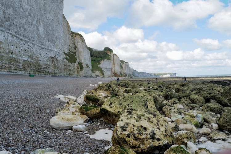 People Walking On Rocks By Cliff