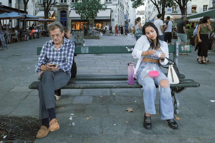 Man And Woman Sitting On Urban Bench