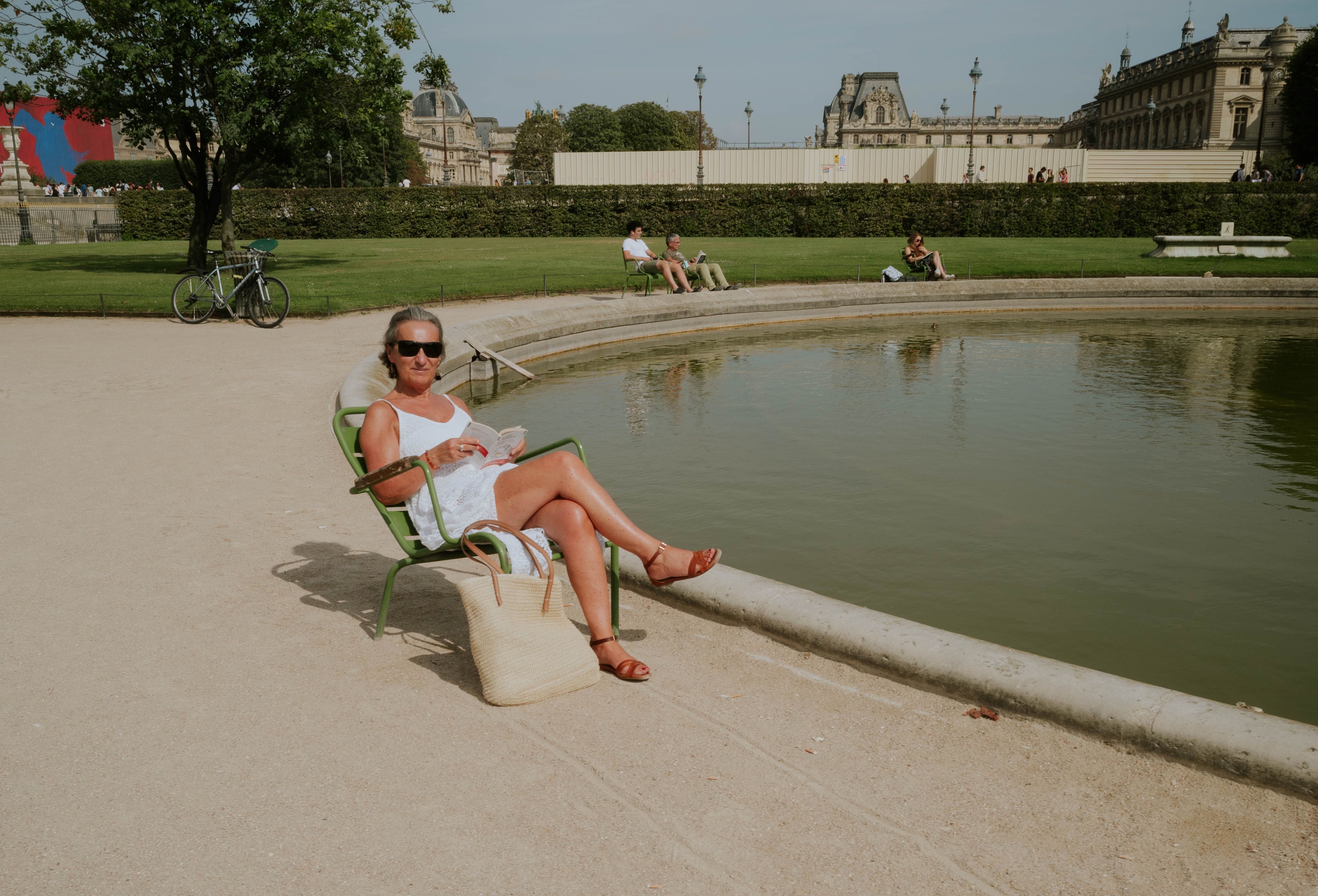 People seeking shade in a Parisian park during a summer heatwave, illustrating high temperatures
