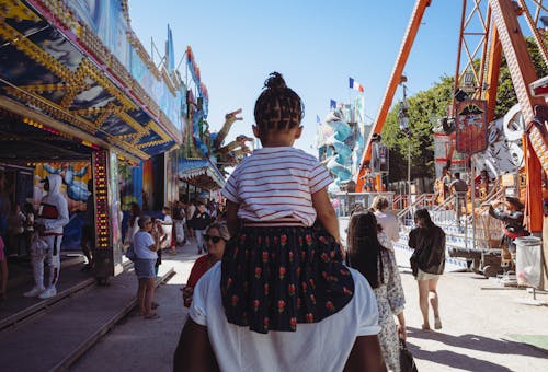 Father Carrying Daughter in Amusement Park