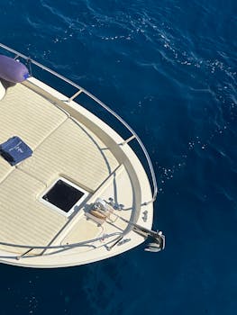 A top view of a luxury yacht's bow floating on a deep blue ocean.