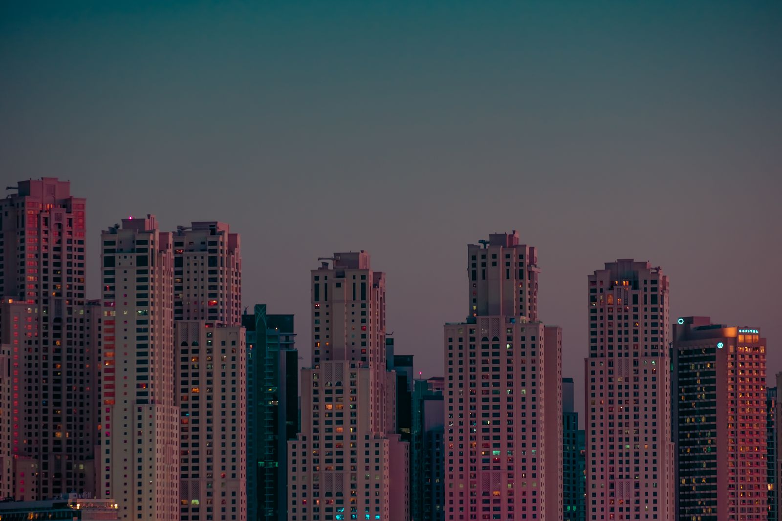 A city skyline of towers at twilight
