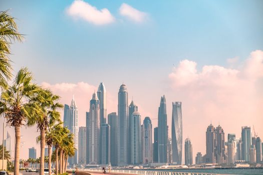 Scenic view of Dubai's iconic skyline with lush palm trees during a clear day.
