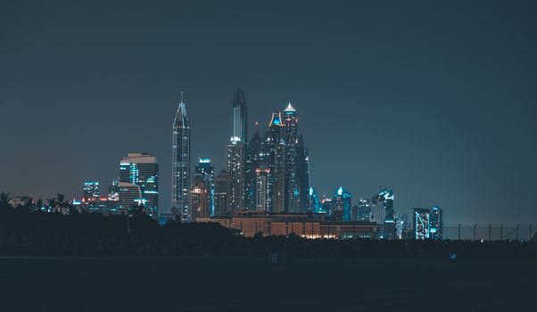 Magnificent view of Dubai skyline at night, showcasing iconic skyscrapers illuminated against a dark sky.