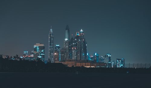Free Magnificent view of Dubai skyline at night, showcasing iconic skyscrapers illuminated against a dark sky. Stock Photo