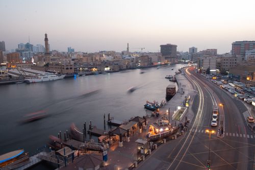Free Aerial view of Dubai Creek at twilight showcasing bustling waterfront and cityscape. Stock Photo