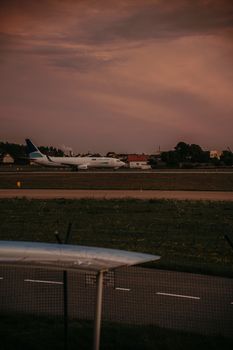 Commercial airplane on an airport runway during dusk, capturing the essence of travel and transportation.