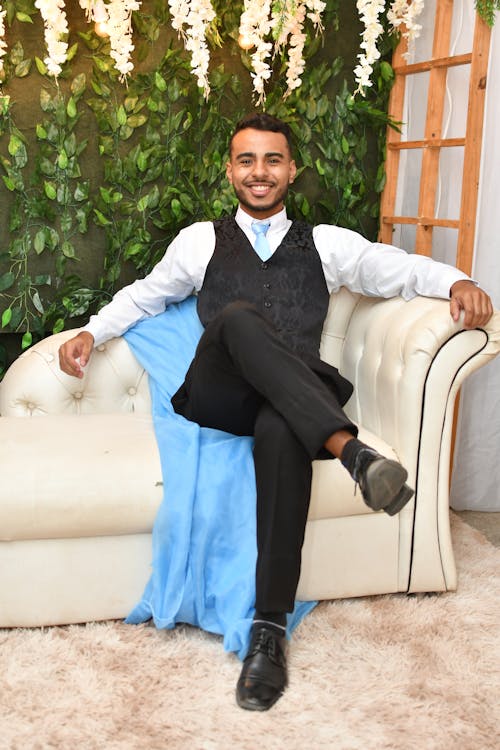 Elegant Young Man in a Suit Sitting on a Sofa