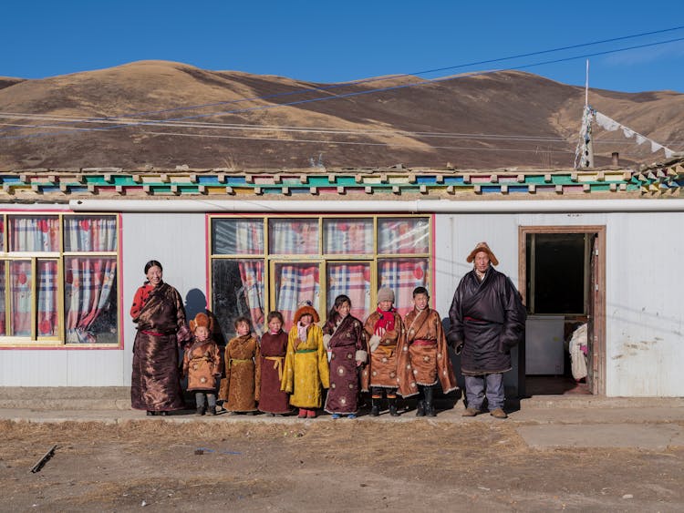 Family Standing In Front Of House