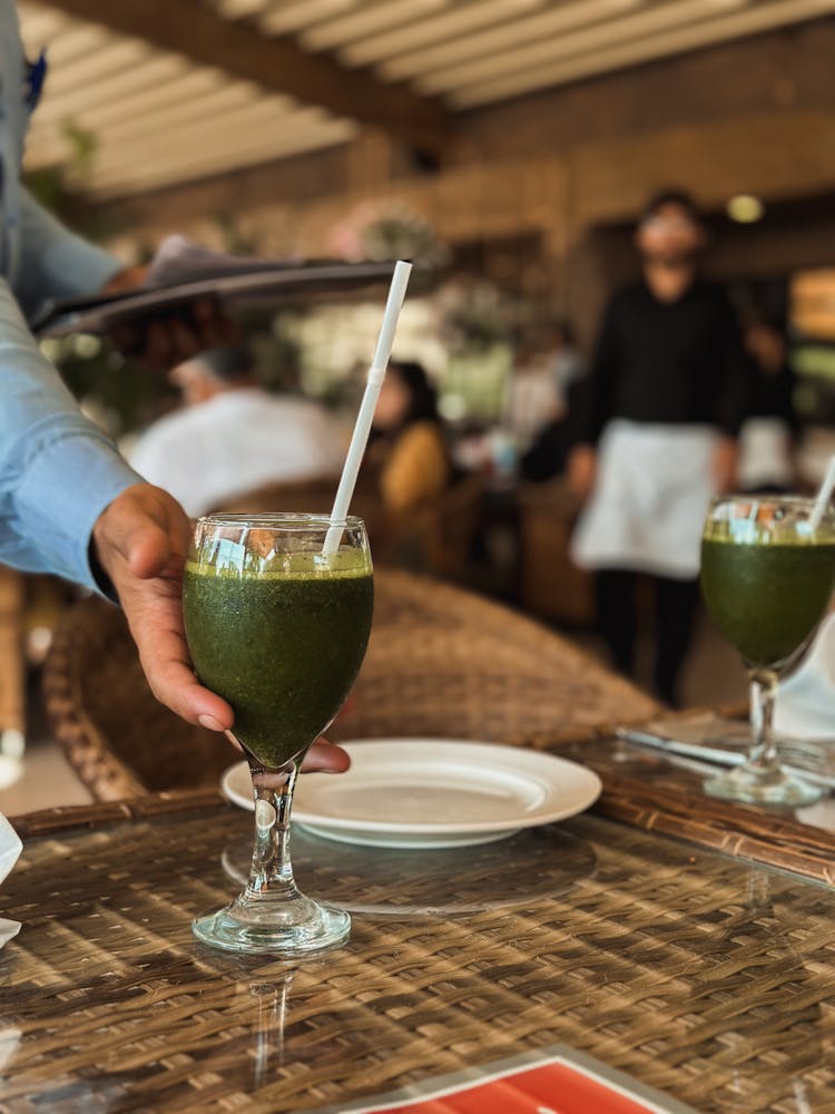 Hand Holding Glass With Green Cocktail