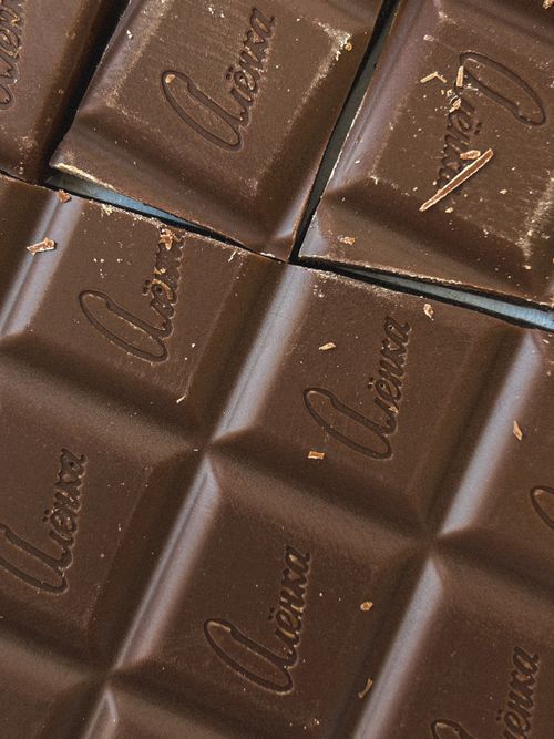 Free Tempting close-up of rich dark chocolate squares with 'Vienna' engraving, perfect for dessert presentations. Stock Photo