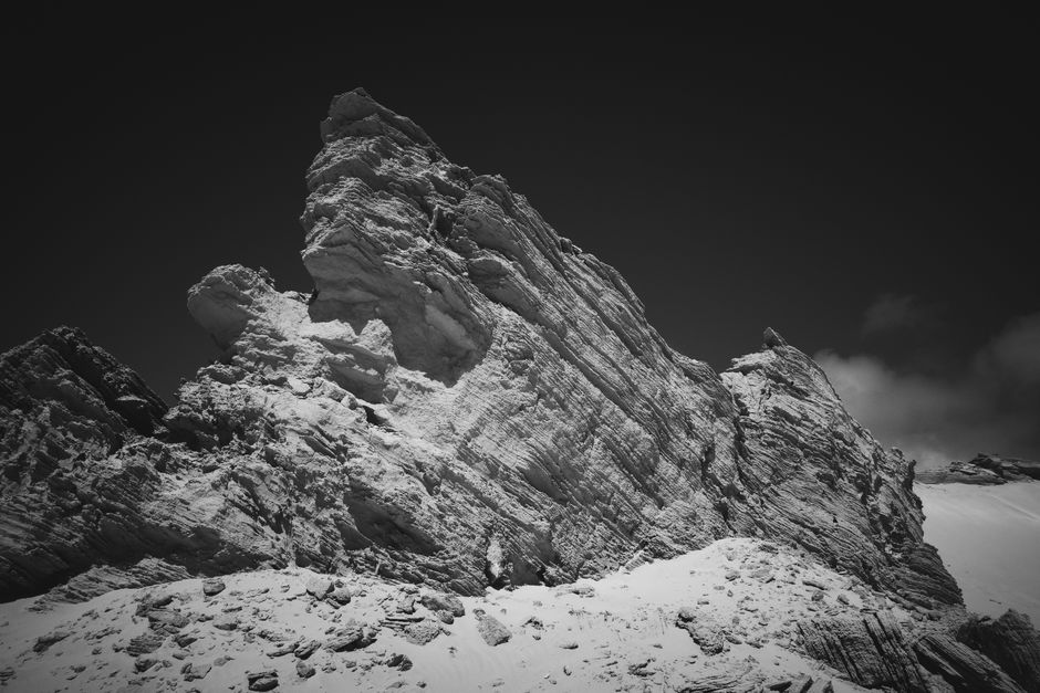 Stunning black and white photograph of a rugged mountain peak with rocky details.
