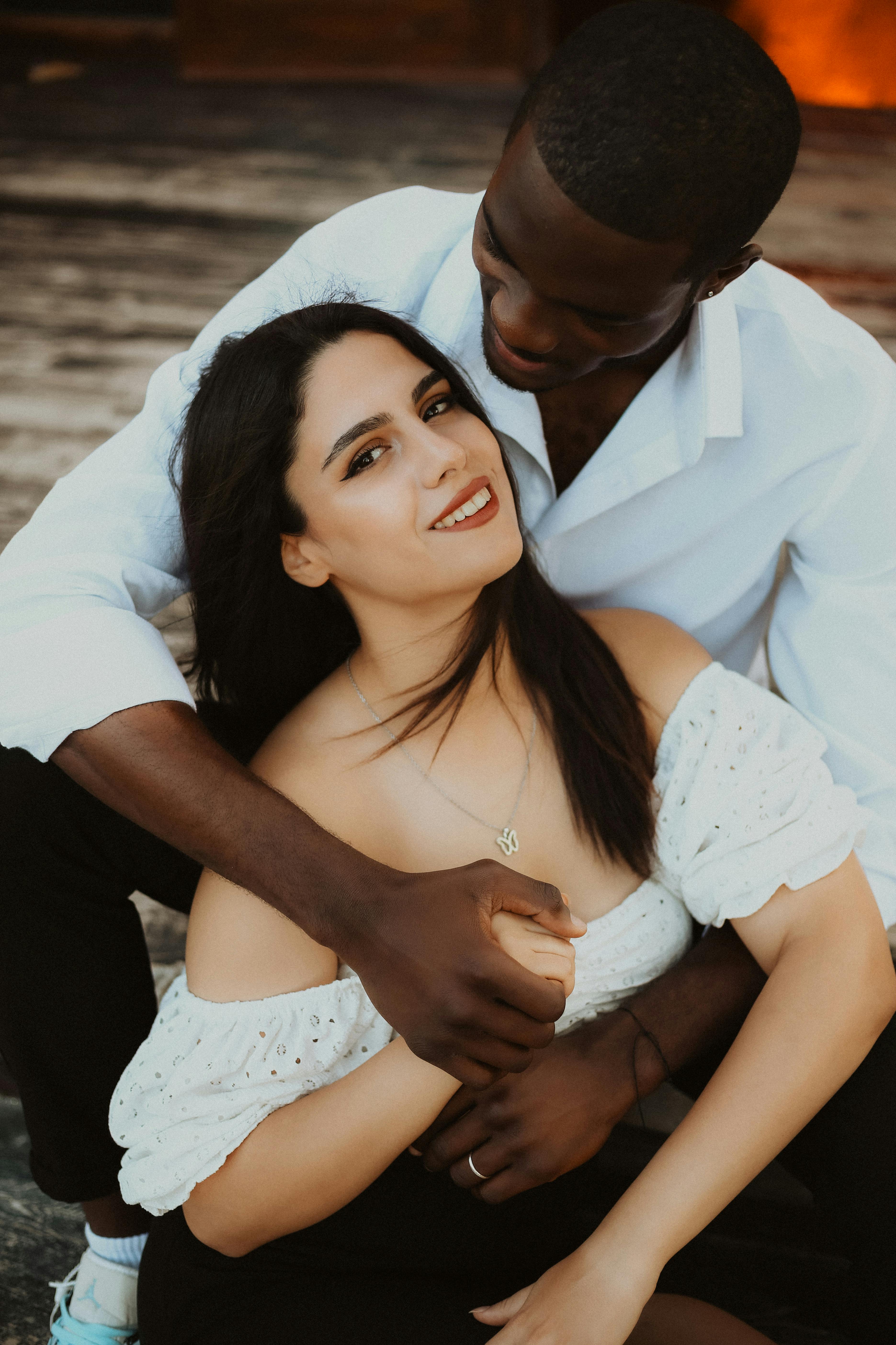 Young Couple Embraces by a Black Rock Cliff · Free Stock Photo