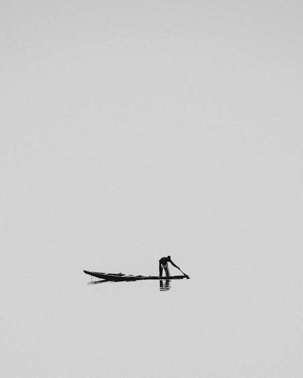 Man on a Gondola on the Sea Blending with the Sky on the Horizon · Free ...