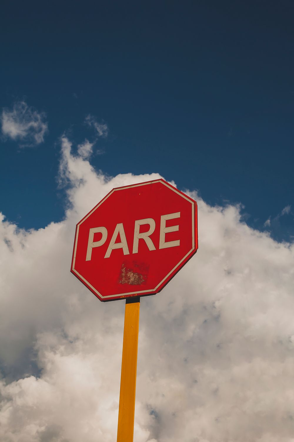 Stop Sign In Peru Peruvian Stop Sign on a Yellow Pole · Free Stock Photo