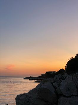 Scenic sunset view over Croatia's rocky coastline with a tranquil sea.