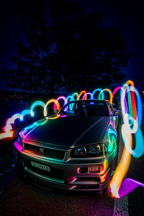 Kostenloses Foto zum Thema: auto, automobil, beleuchtet, bunte lichter,  dunkel, fahrzeug, nissan skyline gt r, vertikaler schuss