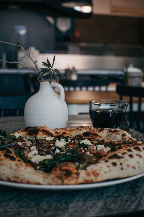 Free A delicious gourmet pizza served with a drink, set in a cozy Ankara restaurant setting. Stock Photo