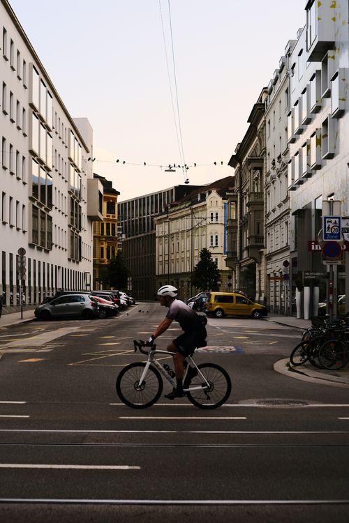 Free Cyclist on a street in Innsbruck, Austria, showcasing urban architecture and evening atmosphere. Stock Photo