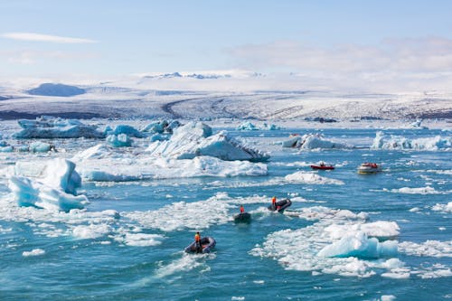 Rafts and Boats Among Melting Glacier Fragments and Icebergs