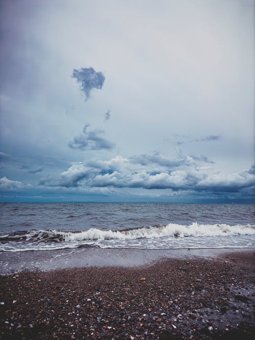 View of the Beach and Seascape under a Cloudy Sky 