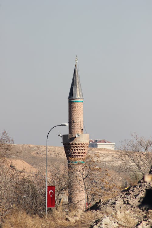 Tower of the Mosque Next to a Street Lamp with the Turkish Flag