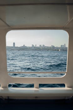 View of Istanbul cityscape across the sea viewed through a ferry window.