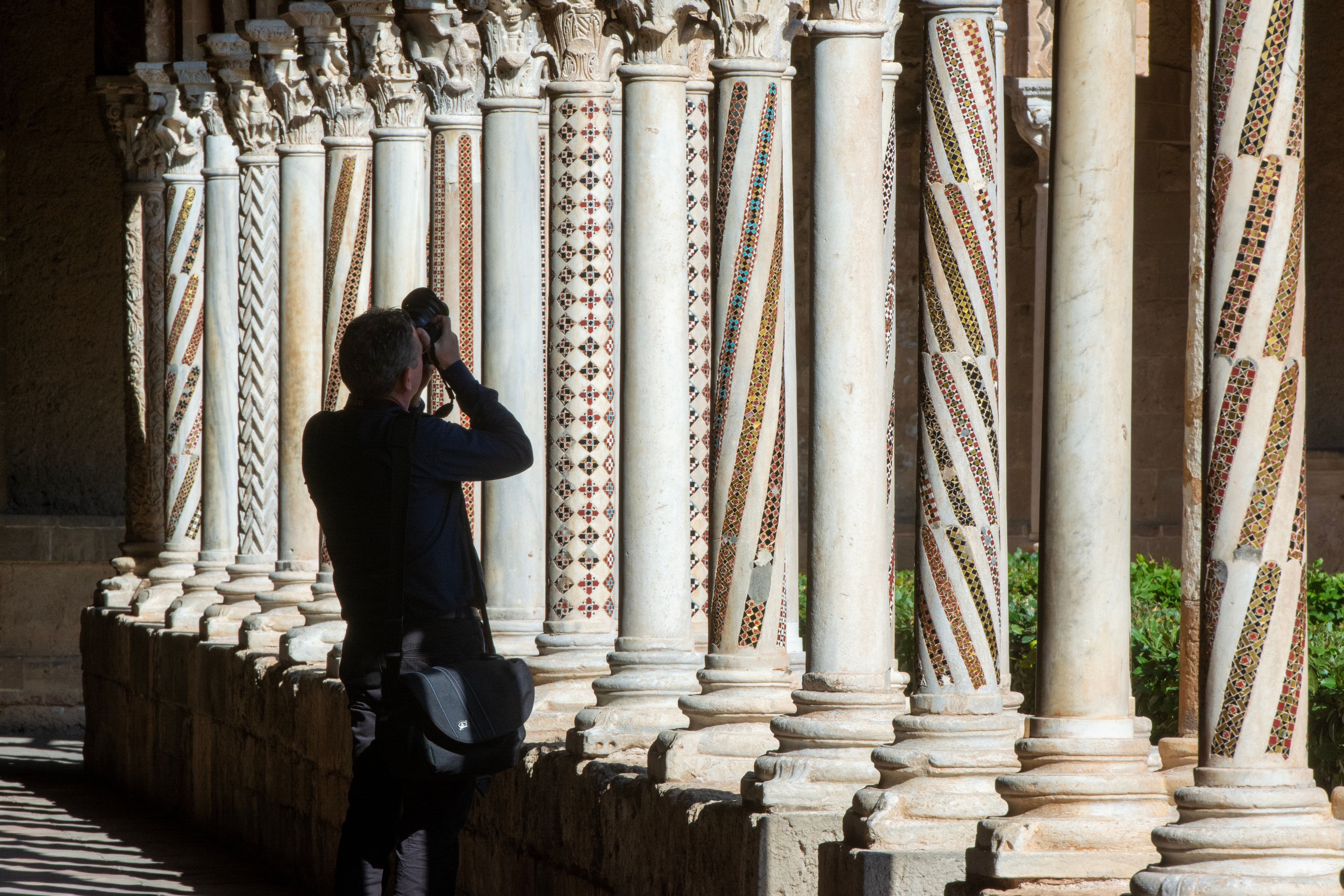 Photographer takes picture of intricate columns at Monreale, Sicily showing artistic architectural details.