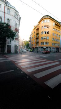 City street corner with buildings and zebra crossing at dawn.
