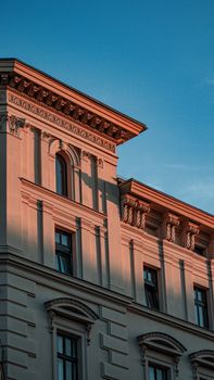 Sunlit neoclassical architecture in Berlin's urban skyline during twilight.