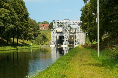 Free A historic waterway lift bridge against a scenic landscape with trees and canal. Stock Photo