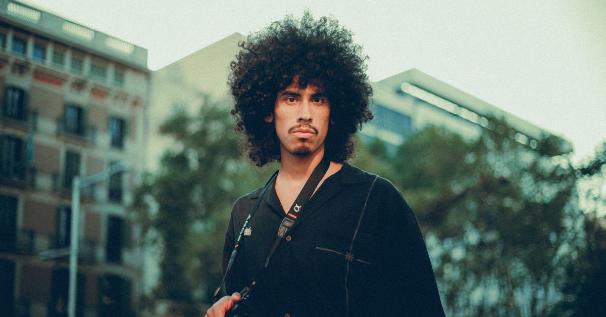 城市街景中,一位留着 afro 卷发的男子
