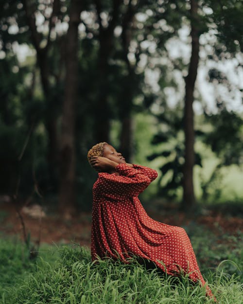 Sitting on Grass in Forest Woman Covering Ears