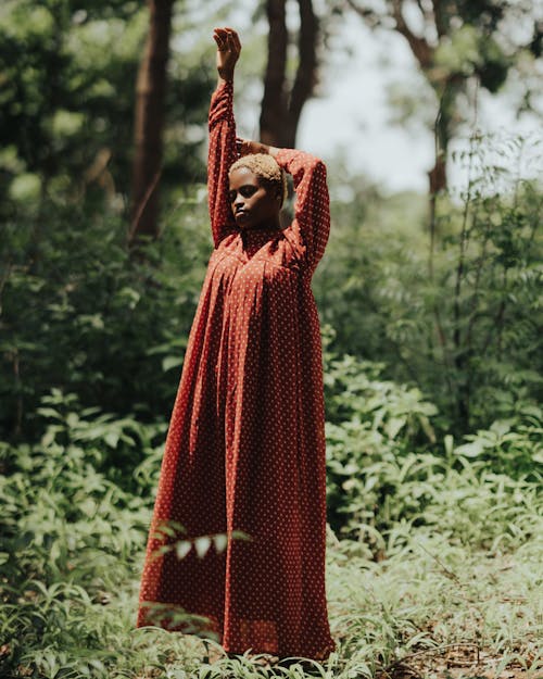 Woman Standing with Arm Raised in Forest