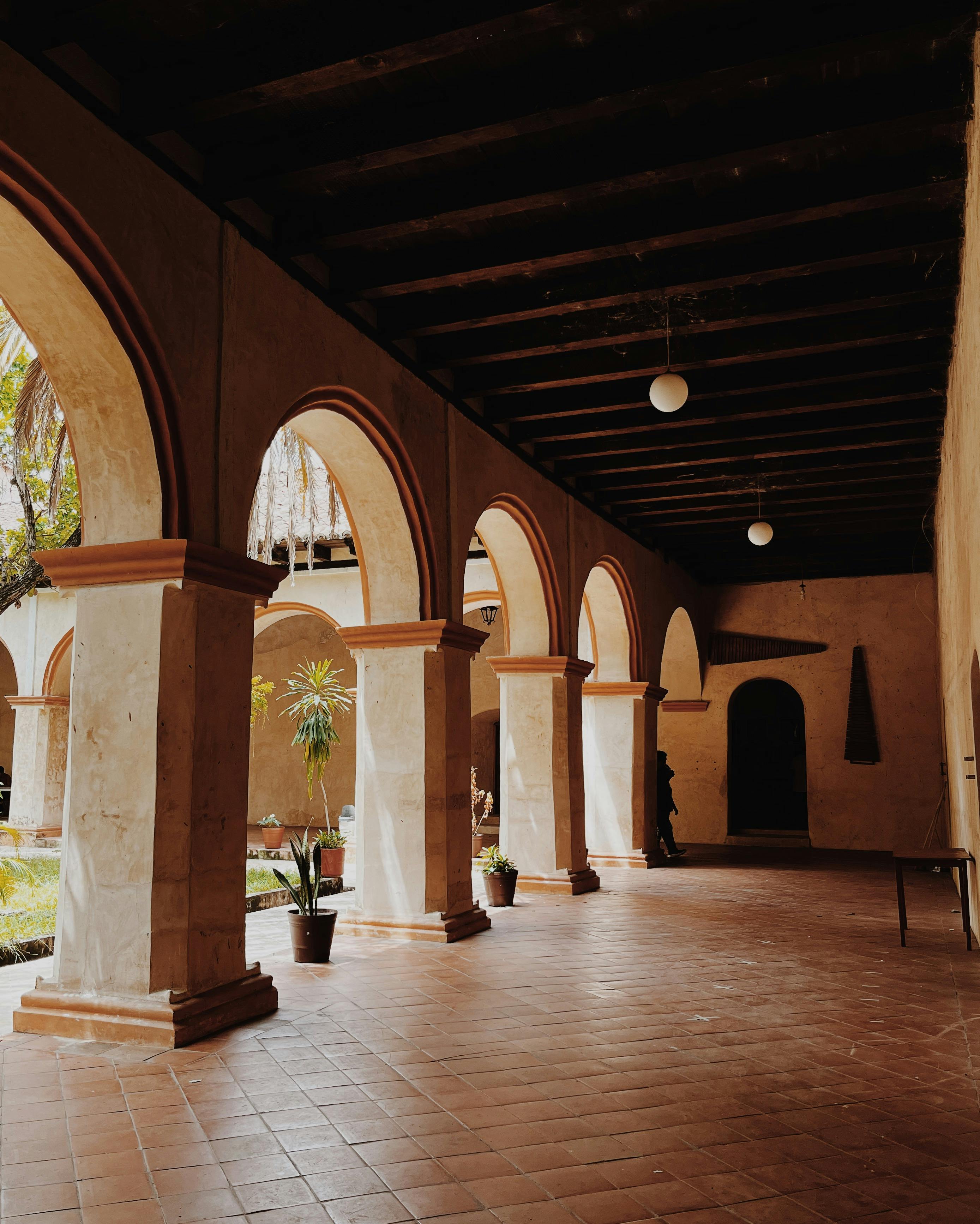 Elegant colonial arches in a Chiapa de Corzo courtyard with warm lighting.