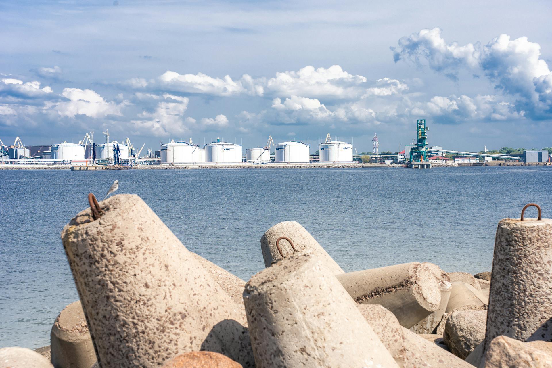 View of an industrial port and concrete wavebreakers on a sunny day in Ventspils, Latvia.