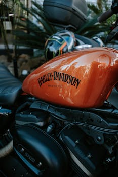 Detailed view of a Harley Davidson motorcycle engine with focus on the orange fuel tank.