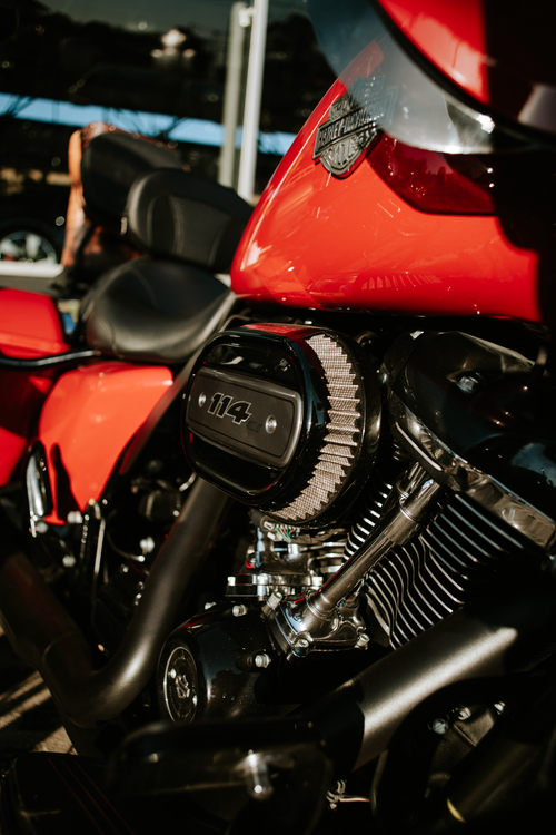 Free Detailed shot of a red motorcycle engine with chrome elements in sunlight. Stock Photo