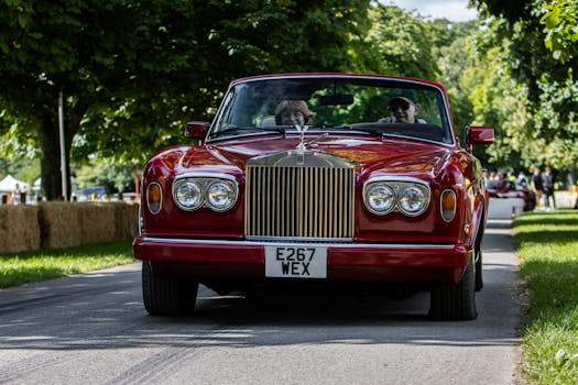 A classic red Rolls-Royce driving outdoors at the Goodwood Festival Speed.