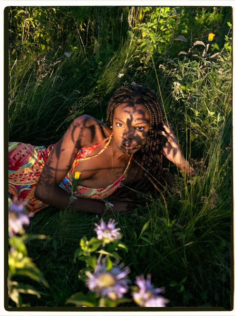 Stunning portrait of a woman in a colorful dress, captured in a serene garden setting in Montreal.
