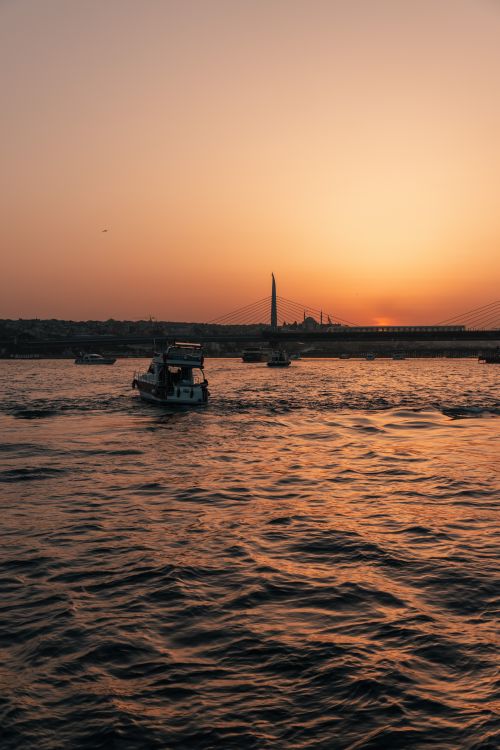 Free Scenic view of boats on the Golden Horn at sunset in İstanbul, capturing vibrant sky and water reflections. Stock Photo