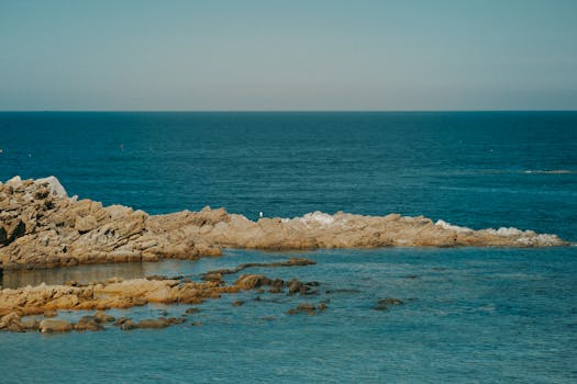 Explore a serene coastal landscape featuring rugged rocks and tranquil ocean waves.