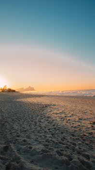 Scenic sunrise over a serene beach in Rio de Janeiro, Brazil with golden sands and ocean waves.