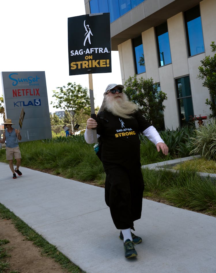 Man With Long Beard Standing With Banner